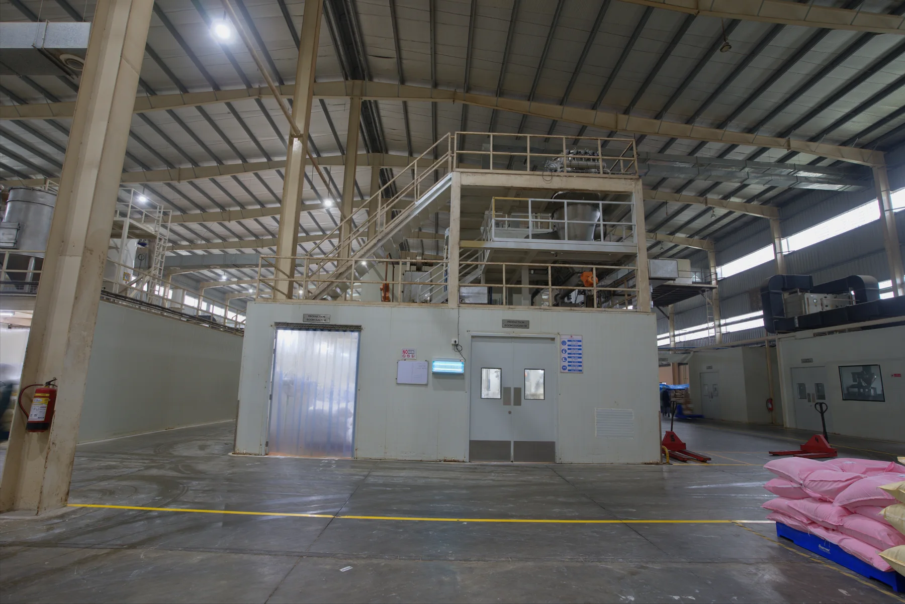 Wide production hall with processing structures, access platforms and marked floor areas inside a Shree Additives facility