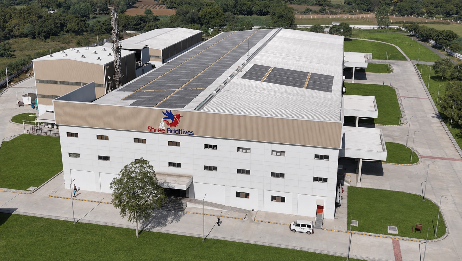 Aerial view of the Shree Additives factory with solar-panel roofs and digitally visualised lawns and paving